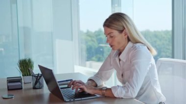 Close up of stressed and upset female office worker with laptop working indoor. Portrait of adult pretty businesswoman receiving email with bad news feeling frustrated sitting at desktop in office