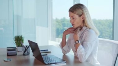 Office worker employee feels suffocated working on laptop turn on air conditioner using remote control, cooling system or humidifier. Concentrated woman sets a comfortable temperature Hot summer time