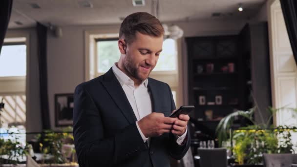 Young Handsome Businessman Suit Standing Alone Restaurant Holding Smartphone Use — Vídeos de Stock