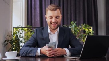 Satisfied Happy Smiling Freelancer Businessman winning lottery, count the money, Laptop with Amazing News. Business man Professional Sitting in restaurant Receiving new Successful Project, Betting