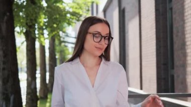İş kadını portresi. Kız CEO kadın lider kameraya çok hoş görünerek gözlüğünü çıkarıyor. Girişimci dışarıda poz veriyor. Kendine güveni tam bir iş kadını.