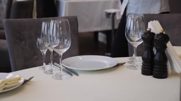 宴会ホールでお祝いする前に ウェイターの女性の手のショットは テーブルの上に布ナプキンを置きます 晩餐会だ レストランでガラスとエレガントな結婚式の空のテーブル — ストック動画
