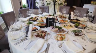 Bir sürü yiyeceği olan bir restoranda düğün ziyafeti. Yuvarlak masada servis edilen şenlik tabakları. Büyük bir ziyafetin başlamasını bekleyen tabaklarla dolu bir masa. Düğün için. Parti zamanı. Kutlama