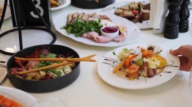 Kurumsal doğum günü partisinde ya da restoranda yapılan düğün kutlamalarında farklı deniz ürünleri ve aperatiflerle güzel servis edilen ziyafet masası. Beyaz iç dekorasyonla dekore edilmiş.