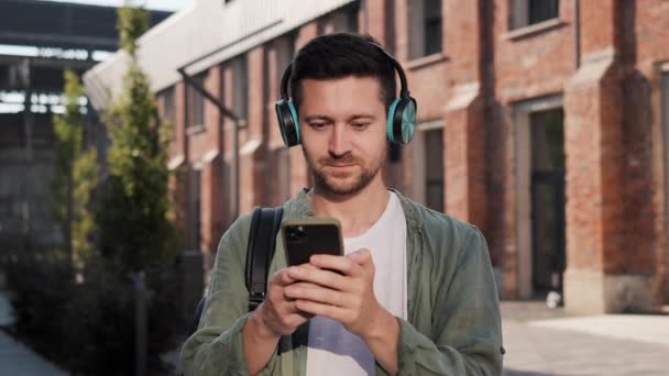 Szczęśliwy Człowiek Zielonym Białym Ubraniu Casual Nosić Słuchawki Bezprzewodowe Słuchanie — Wideo stockowe
