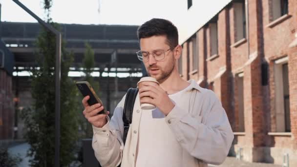 Close Young Confident Handsome Man Walking Outdoors Sipping Coffee Reading — Stock Video
