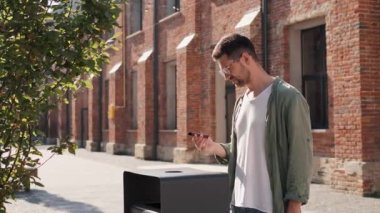 Sigara içmeyi bırak, serbest giyinmiş dalgın bir iş adamı gözlüklü, çöpe elektronik sigara atıyor sonra da dışarı çıkıp kameraya bakıyor. Genç adam sağlığı için sigarayı bıraktı.