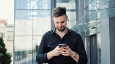 Sosyal medyada sohbet eden genç iş adamı cep telefonu uygulaması, akıllı telefon kullanıyor.