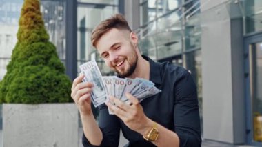 Muhteşem mutlu iş adamı portresi. Sokakta para sayıyor.