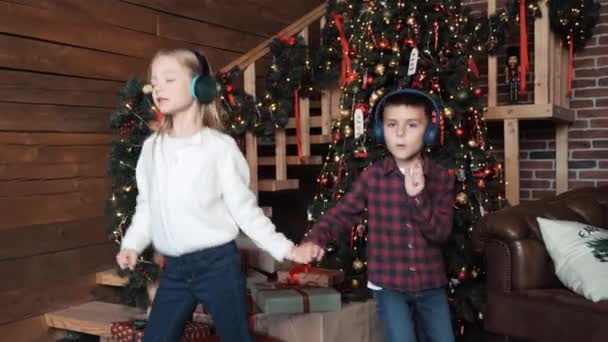 Niños Auriculares Escuchando Música Bailando Divirtiéndose Cerca Del Árbol Navidad — Vídeos de Stock