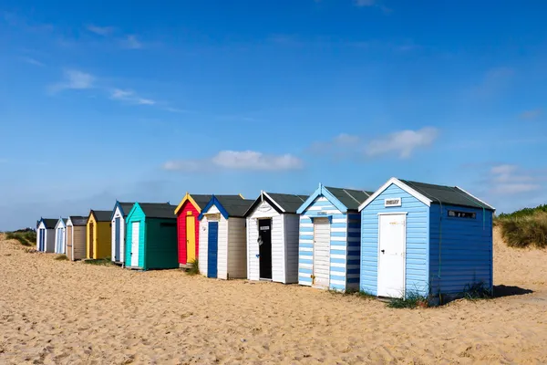 Una fila de cabañas de playa de colores brillantes en Southwold Suffolk Imagen de stock