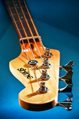 Close-up elektrische basgitaar hoofd en tuning haringen