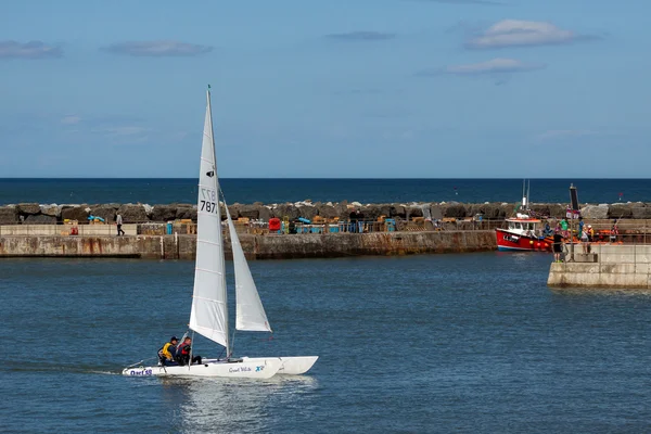 Grote witte catamaran zeilen in de haven van staithes — Stockfoto