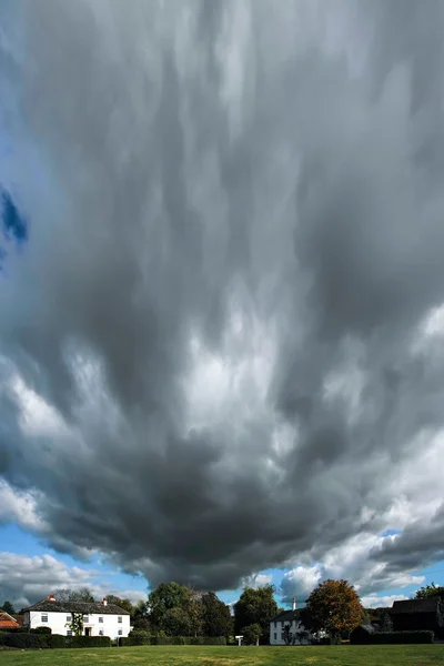 Rychle pohybující bouřkové mraky nad rushlake zelená — Stock fotografie