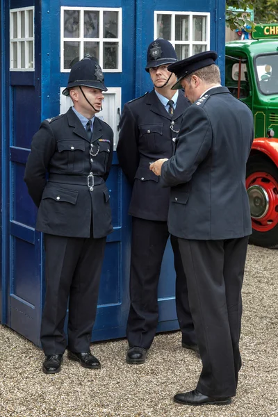 Polizisten vor einer altmodischen englischen blauen Polizeibox — Stockfoto
