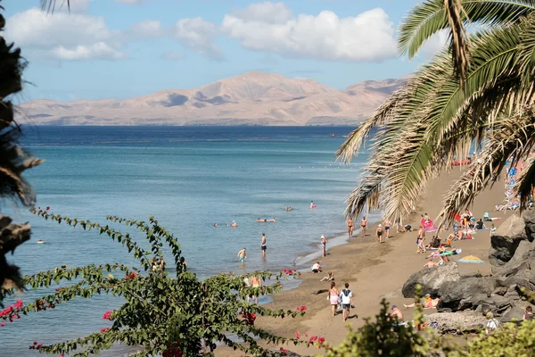 Gente relajándose en una playa en Lanzarote España — Foto de Stock