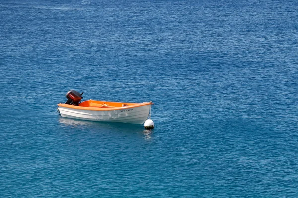Barco de remos con motor fueraborda amarrado frente a la costa de Lanzarot —  Fotos de Stock