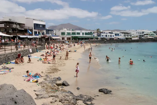 Människor njuter av stranden och havet i puerto del carmen, lanzarote — Stockfoto