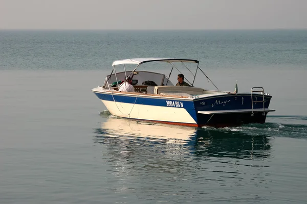 En motorbåt som sakta cruising på Gardasjön-Italien — Stockfoto