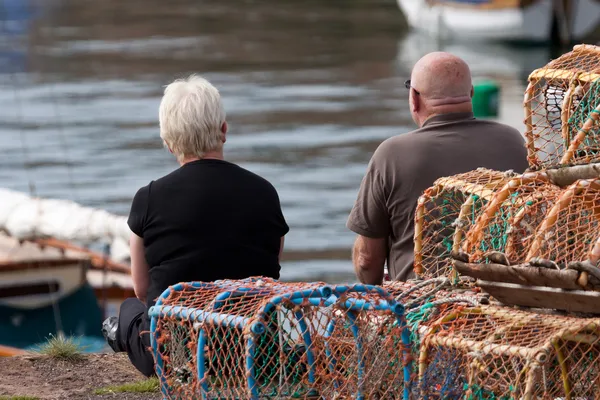 Two people sitting on the quayside at Dunbar — Stock Photo, Image