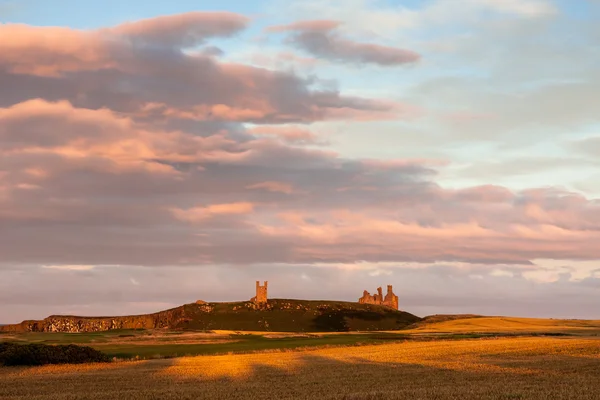 Solnedgång vid Dunstanburghs slott — Stockfoto