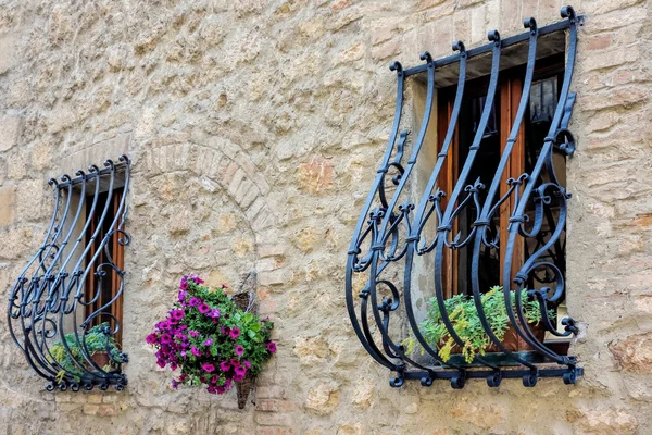 Barras de seguridad de hierro forjado sobre ventanas en Pienza Imagen de archivo
