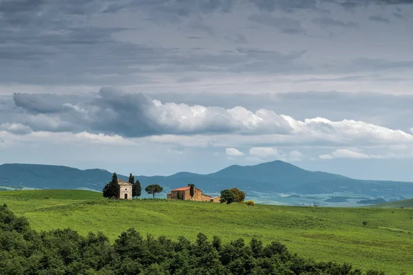 Kościółek na szczytu wzgórza w val d'orcia w pobliżu san quiricio — Zdjęcie stockowe