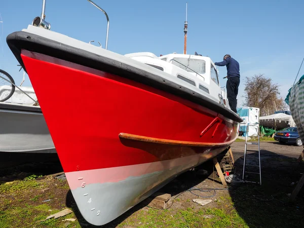 Unidentified man painting his boat in Faversham Kent on March 29