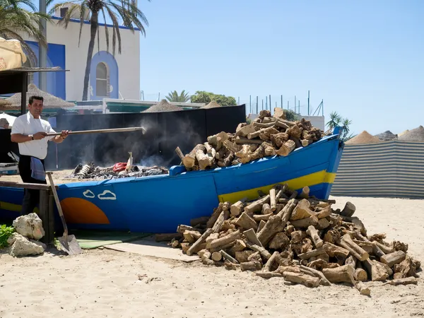 Man matlagning fisk på stranden i marbella — Stockfoto