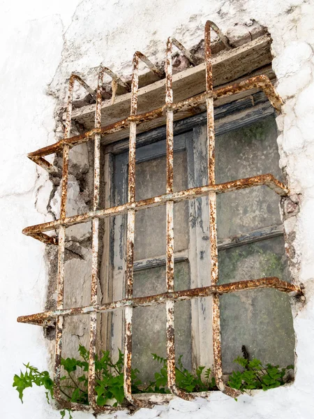 Rostende Gitter über einem Fenster eines verfallenen Gebäudes in casares s — Stockfoto