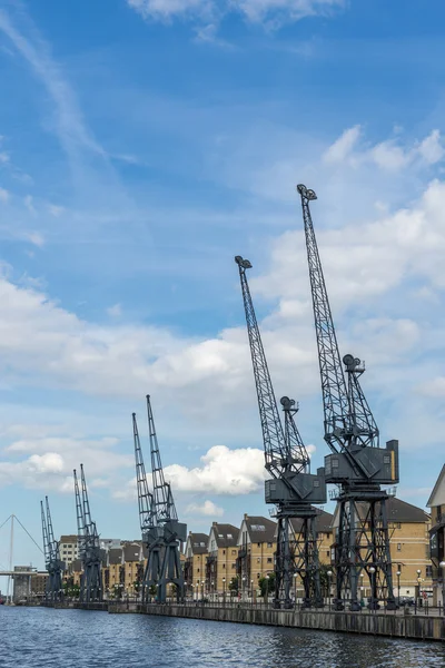 Old dockside cranes alongside a waterfront development — Stock Photo, Image