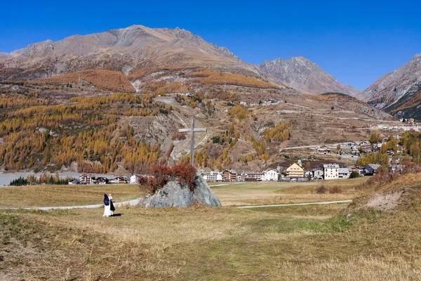 Freira tirando uma foto da cruz em Cogne, na Itália — Fotografia de Stock