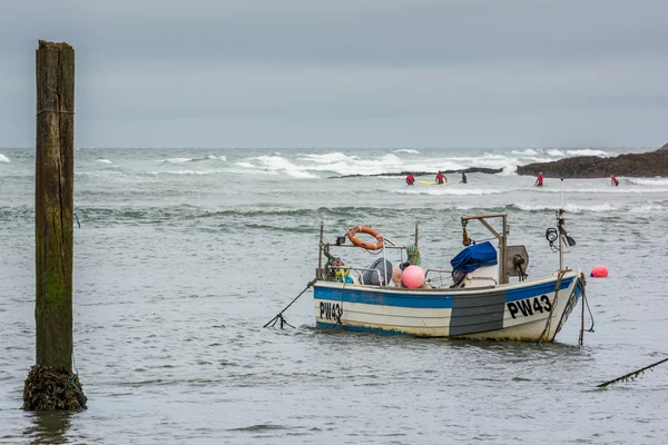 Boat and surfers at Bude — Stock Photo, Image