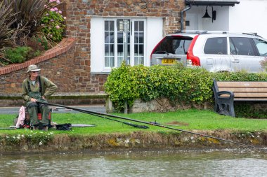 BUDE, CORNWALL, UK - 15 Ağustos 2013 'te Cornwall' daki Bude kanalında balık tutan adam. Kimliği belirsiz bir adam.