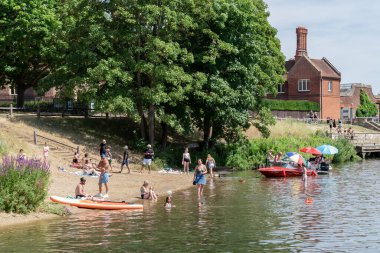 Hampton Court, Surrey, İngiltere - 15 Temmuz 2022: 15 Temmuz 2022 'de Hampton Court' ta Thames Nehri 'nin tadını çıkaran insanlar. Tanımlanamayan kişiler
