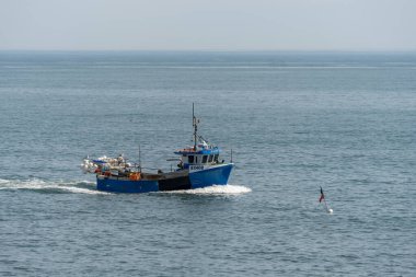 SCARBOROUGH,  NORTH YORKSHIRE, UK - JULY 18: Fshing boat heading towards Scarborough, North Yorkshire on July 18, 2022