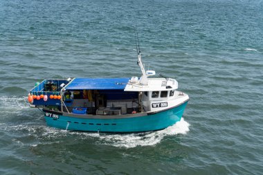 Whitby, North York, İngiltere - 19 Temmuz 2022 'de Whitby, Kuzey Yorkshire' a doğru giden balıkçı teknesi. Kimliği belirsiz biri.