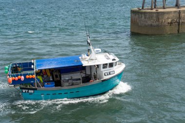 Whitby, North York, İngiltere - 19 Temmuz 2022 'de Whitby, Kuzey Yorkshire' a doğru giden balıkçı teknesi. Kimliği belirsiz biri.