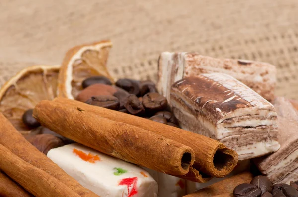 Sweets, cinnamon, nuts and coffee beans on a saucer — Stock fotografie