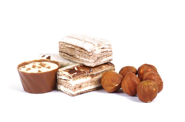 Chocolate and nuts over white — Stock Photo, Image