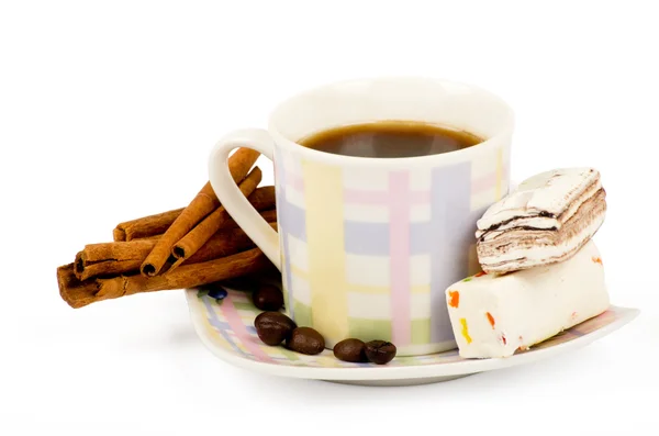 Kaffeetasse mit Süßigkeiten und Zimt auf weißem Hintergrund — Stockfoto