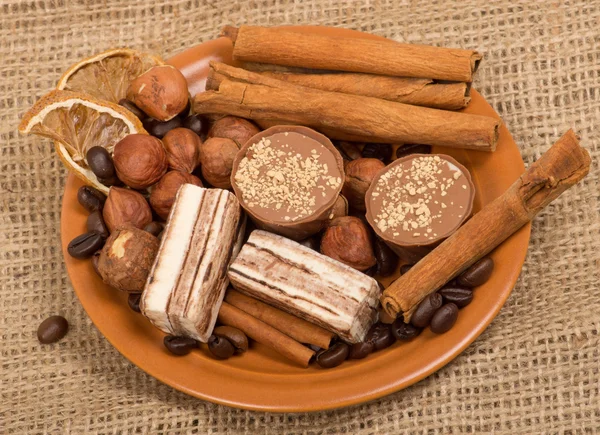 Dolci, cannella, noci e chicchi di caffè su un piattino — Foto Stock