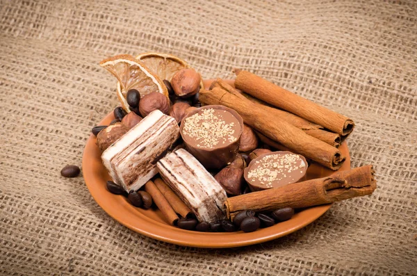 Свитки, корица, орехи и кофейные зёрна на тарелке — стоковое фото