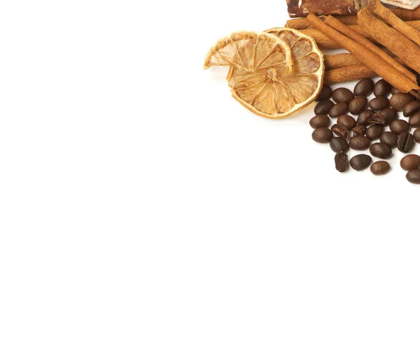 Granos de café, canela, limón y dulces sobre blanco — Foto de Stock