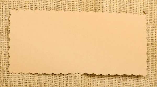 Старая бумажная бирка на мешковине — стоковое фото