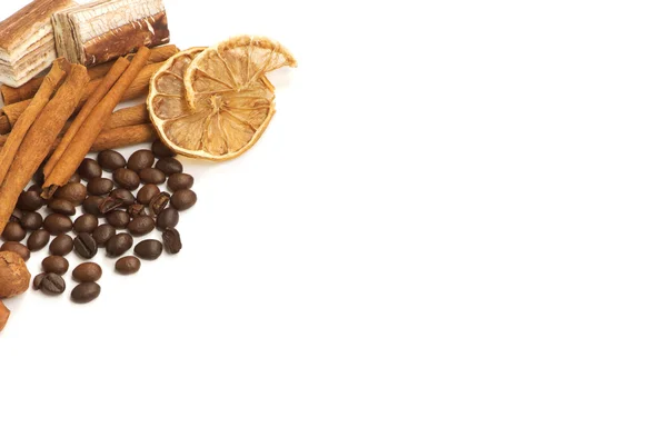 Kávová zrna, skořice, citron a sladkostí nad bílá — Stock fotografie
