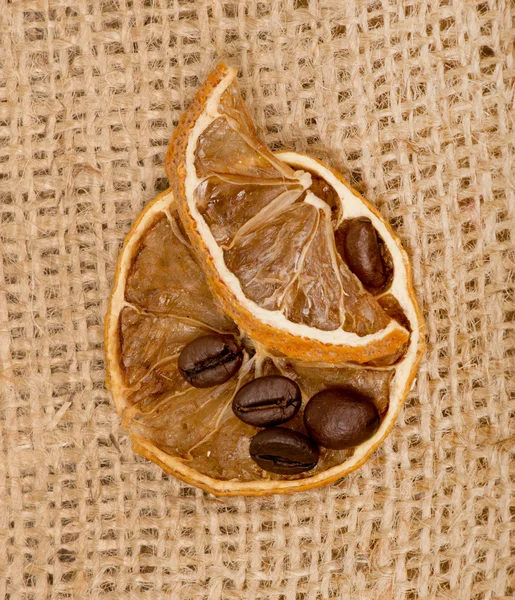 Citrony a kávová zrna na pytlovina — Stock fotografie