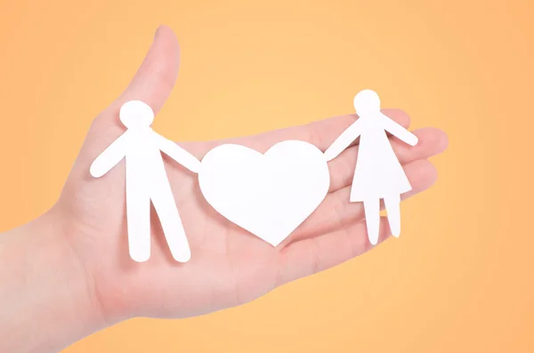 Paper family in hands isolated on orange — Stock Photo, Image