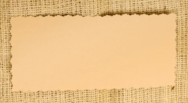 Старая бумажная бирка на мешковине — стоковое фото