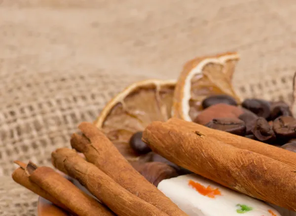 Snoep, kaneel, noten en koffiebonen op een schotel — Stockfoto